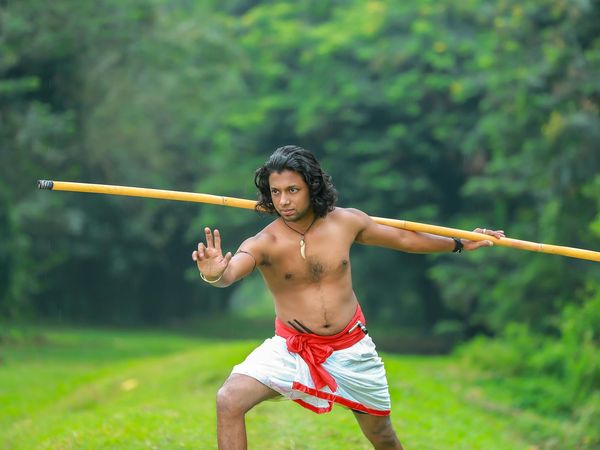 Focused man in an athletic pose showing balance and strength.