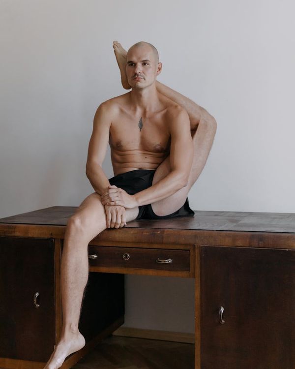 Man performing a controlled strength exercise in a minimalist setting.